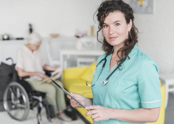 portrait-female-nurse-holding-digital-tablet-standing-front-senior-patient-wheelchair